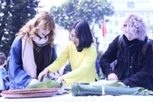 Des étudiantes étrangères participent à la confection de banh chung. Photo: baodantri