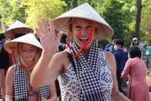 Les Américains portant des nón lá (chapeaux coniques vietnamiens) et khăn rằn (châles traditionnels à carreaux noir et blanc) à Ho Chi Minh-Ville, le 8 avril 2022. Photo de VnExpress .
