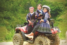 Vàng Thi Ly (1ère à gauche) accompagne deux touristes lors de leur visite à La Pán Tân. Photo : CVN/VNA.