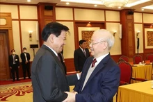Le Secrétaire général du Parti communiste du Vietnam Nguyên Phu Trong (à droite) accueillant le Secrétaire général du Parti populaire révolutionnaire lao et Président lao Thongloun Sisoulith, à Hanoi, le 26 févier. Photo : VNA.