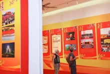 Des visiteurs internationaux visitent une exposition sur le Parti à Hanoi à l'occasion du 95e anniversaire de la fondation du Parti communiste du Vietnam. Photo : VNA.