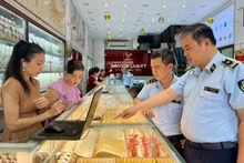 Inspecteurs du marché lors d'un contrôle de routine dans un magasin d'or de l'arrondissement de Cầu Giấy, Hà Nội. Photo : VNA. 