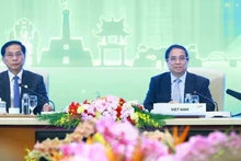 Le Premier ministre Pham Minh Chinh (à droite) préside la discussion plénière de haut niveau sur la « Transition verte durable et centrée sur l'humain ». (Photo : VNA)