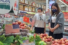 Des consommateurs choisissent des pommes américaines dans un supermarché à Hô Chi Minh-Ville. Photo : nld.com.vn