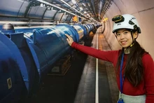 Joni Pham, doctorante à l’Université de Melbourne et physicienne travaillant au CERN, à côté du système ATLAS situé au centre du CERN. Photo : CERN