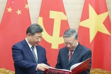 Le secrétaire général du Parti communiste du Vietnam To Lam offre le livre de photo de l'Agence vietnamienne d'Information au secrétaire général du PCC et président chinois Xi Jinping. Photo : VNA.