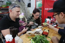 Les touristes étrangers dégustent le bun cha. Photo: sggp
