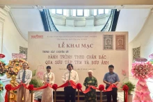 Des délégués coupent le ruban inaugural de l'exposition thématique "Sur les traces de l'Oncle Hô à travers une collection de timbres et de cartes postales". 