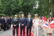 Le président vietnamien Luong Cuong et le président français Emmanuel Macron aux côtés des deux anciens combattants Pham Minh Nghia et William Schilardi. Photo : VNA.