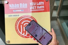Les touristes scannent un panneau équipé de puces NFC au Musée de Da Nang. Photo : NDEL.