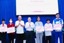 L'ancien vice-Premier ministre permanent Truong Hoa Binh (2e, gauche) remet des bourses d'études aux élèves défavorisés de l'ethnie khmère à Ho Chi Minh-Ville. Photo: VNA