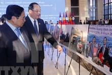 Le Premier ministre Pham Minh Chinh (à gauche) et son homologue lao, Sonexay Siphandone, ont visité jeudi matin une exposition de photos sur les réalisations de la coopération entre le Vietnam et le Laos à Vientiane. Photo : VNA.