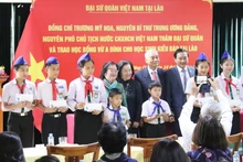 Lors de la cérémonie de remise de 100 bourses aux élèves, qui sont des enfants de Viet kieu au Laos. Photo: Báo Dân tộc và miền núi)