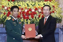 Le Président Vo Van Thuong (à droite) rende une décision sur la promotion du chef d'état-major adjoint de l'Armée populaire du Vietnam, Nguyên Van Nghia, du grade de général de division à celui de général de corps d’armée. Photo : VNA.