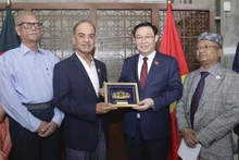 Le président de l'Assemblée nationale, Vuong Dinh Hue (2e à partir de la droite), offre un cadeau de souvenir au président de la Commission des affaires étrangères du Parlement du Bangladesh, Muhammad Faruk Khan (2e à partir de la gauche). Photo: VNA