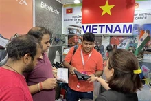 Visiteurs au stand de chaussures vietnamiennes. Photo: VNA