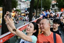 Les touristes découvrant Hô Chi Minh-Ville sur le pont d'un autobus à impériale. Photo : VNA.