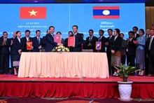Le ministre Nguyen Hong Dien et son homologue laotienne signent le nouvel accord commercial Vietnam-Laos en avril 2024. Photo de : baocongthuong