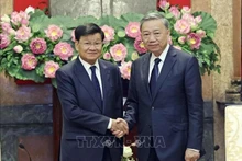 Le président To Lam (droite) et le secrétaire général du PPRL et président lao, Thongloun Sisoulith. Photo : VNA.