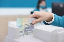 Un caissier de banque compte de l'argent dans un bureau de transaction à Hanoi. (Photo : vietnamfinance.vn)