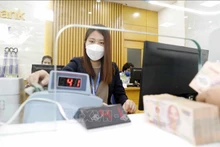 Une transaction dans une banque vietnamienne. Photo: VNA