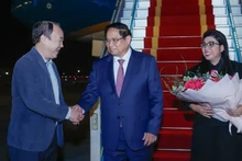 Le Premier ministre Pham Minh Chinh (au centre) et son épouse sont accueillis par le vice-président du bureau du gouvernement Nguyen Sy Hiep à l'aéroport international de Noi Bai. Photo : VNA.