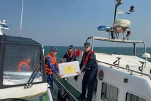 Les garde-côtes vietnamiens et chinois s'offrent les uns aux autres des cadeaux après la fin de leur patrouille conjointe. Photo : VNA.
