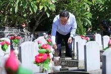 Le président de l'Assemblée nationale, Tran Thanh Man, offre de l'encens sur les tombes des martyrs au cimetière international des Morts pour la Patrie Vietnam - Laos. Photo : VNA.