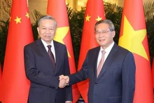 Le secrétaire général du PCV et président vietnamien Tô Lâm (à gauche) et le Premier ministre chinois Li Qiang se serrent la main, à Pékin, le 19 août. Photo : VNA.