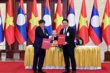 Échange de l'accord de coopération entre les représentants de Vietjet et du ministère lao des Travaux publics et des Transports, le 11 juillet à Vientiane. Photo : VNA.