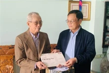 Un responsable du Comité populaire du district insulaire de Hoàng Sa offre des cadeaux à un témoin de l’archipel de Hoàng Sa (Paracels). Photo : VNA.