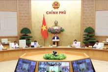 Le PM Pham Minh Chinh (debout) préside la réunion périodique de mars entre le gouvernement et les localités. Photo : VNA.