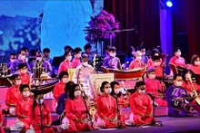 La princesse thaïlandaise (au centre) porte l'ao dai et interprète une œuvre musicale sur le Vietnam. Photo: VNA.