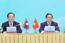 Le Premier ministre vietnamien, Pham Minh Chinh (à droite) et son homologue laotien, Sonexay Siphandone, lors de la conférence sur la coopération en matière d’investissement Vietnam - Laos. Photo : VNA.