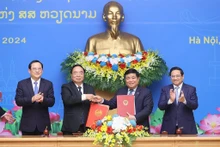 Le PM vietnamien, Pham Minh Chinh (1er à droite) et son homologue laotien, Sonexay Siphandone, supervisent la signature du procès-verbal de la 46e session du Comité intergouvernemental sur la coopération bilatérale Vietnam - Laos, le 7 janvier à Hanoi. Photo : VNA.