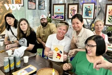 En visitant l'atelier Vun Art, les touristes étrangers peuvent expérimenter la réalisation de peintures sur tissus avec l’aide des artisans handicapés de l’atelier. Photo: VOV.