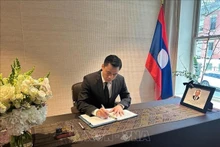 L'ambassadeur Dang Hoang Giang signe le registre de condoléances à la Mission permanente du Laos auprès de l’ONU à New York. Photo : VNA. 