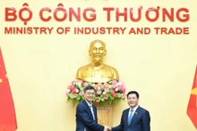 Le ministre vietnamien de l’Industrie et du Commerce Nguyen Hong Dien (à droite) et Chen Gang, membre du Comité central du Parti communiste chinois, secrétaire du Comité du PCC et président du Comité permanent de l'Assemblée populaire de la région autonome Zhuang du Guangxi, Chine. Photo : VNA. 