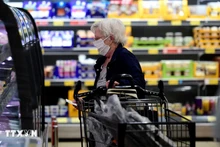 Une femme fait ses courses dans un supermarché en Allemagne. Photo : VNA.