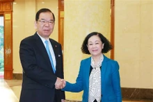 La membre du Bureau politique et Permanente du Secrétariat du Comité central du PCV, Truong Thi Mai (à droite), et le président du Présidium du Comité central du PCJ, Kazuo Shii, se serrent la main, à Hanoi, le 25 décembre. Photo : VNA.
