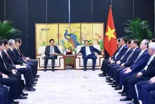 Le PM Pham Minh Chinh (droite) rencontre le président de la région autonome Zhuang du Guangxi (Chine) Lan Tianli. Photo : VNA.