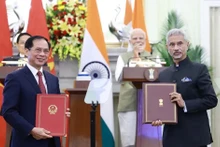Les responsables des ministères des Affaires étrangères du Vietnam et de l’Inde s’échangent l'accord entre les deux gouvernements permettant aux proches des membres des missions diplomatiques et des consulats de travailler contre rémunération. Photo : VNA