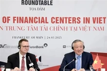 Le vice-Premier ministre permanent Nguyên Hoa Binh (à droite) préside la table ronde sur le développement des centers financiers au Vietnam. Photo : VNA.