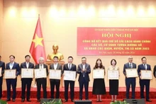 Le président du Comité populaire de Hanoï, Tran Sy Thanh (6e, à droite), remet des satisfecits aux collectivités excellentes en matière de réforme administrative en 2023. Photo: NDEL.