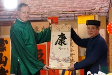 L’ambassadeur d’Israël au Vietnam, Yaron Mayer (à gauche), demande une calligraphie porte-bonheur à l’occasion du Nouvel An lunaire 2024. Photo : thoidai.