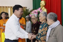 Le Président vietnamien Vo Van Thuong (à gauche) remet des cadeaux à des contributeurs à la cause révolutionnaire, à des familles bénéficiaires de politiques sociales dans le district de Trà Ôn, province de Vinh Long. Photo : VNA.