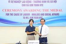 Le vice-ministre vietnamien du Travail, des Invalides de guerre et des Affaires sociales, Nguyen Ba Hoan (à droite), remet l’insigne « Pour l'œuvre du travail, des invalides de guerre et des affaires sociales » à Kim Yoon Hye, attaché au travail et à l'emploi de l'ambassade de la République de Corée au Vietnam, le le 18 septembre à Hanoi. Photo : molisa.gov.vn.