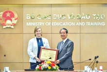 Le ministre vietnamien de l'Éducation et de la Formation, Nguyen Kim Son (à droite), remet l’insigne « Pour la cause de l'éducation du Vietnam » à Rana Flowers, représentante en chef du Fonds des Nations Unies pour l'Enfance (UNICEF) au Vietnam, le 1er juillet à Hanoï. Photo: thoidai.