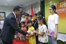 Le président de l'association Khmer – Vietnam au Cambodge, Sim Chy (à gauche), remet des cadeaux aux enfants d'origine vietnamienne au Cambodge. Photo : NDEL.