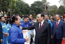Le Président de l'Assemblée nationale, Vuong Dinh Huê, offre des cadeaux du Têt à des travailleurs de Hanoï. Photo : VNA.
